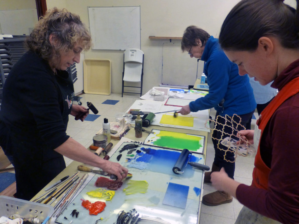 Kathryn Kain (left) helping participants create monotypes at the Davis Art Center.