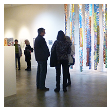 photograph of 11 visitors standing among artwork at the CSP exhibition "First Impressions."